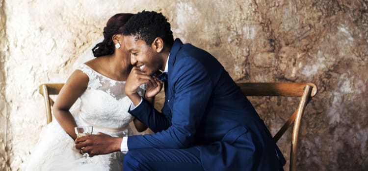 a couple whispers in each other's ears after their wedding ceremony