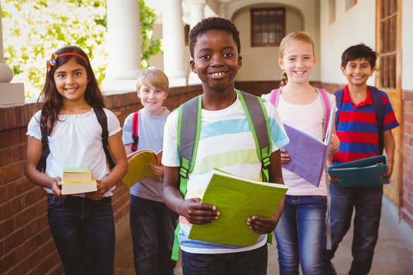 smiling children holding school supplies